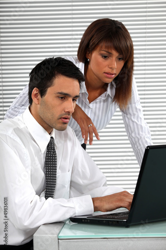 Photo: co-workers in front of laptop co-workers in front of laptop