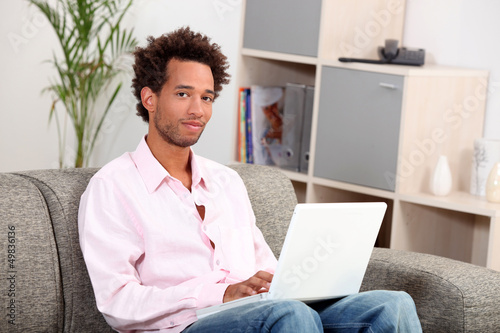 Photo: Couple sitting on sofa with computer Couple sitting on sofa with computer