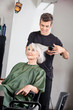 Hairstylist Straightening Female Client's Hair