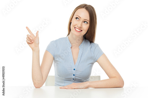 Photo: Smiling woman pointing up Smiling woman pointing up