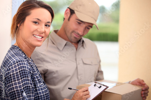 Photo: Woman signing for a package Woman signing for a package