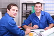 Two manual worker in the office checking stock levels