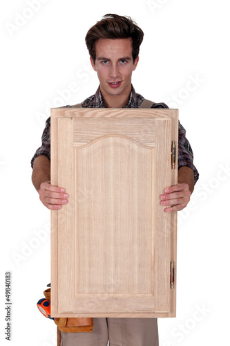 Photo: Carpenter holding wooden door Carpenter holding wooden door