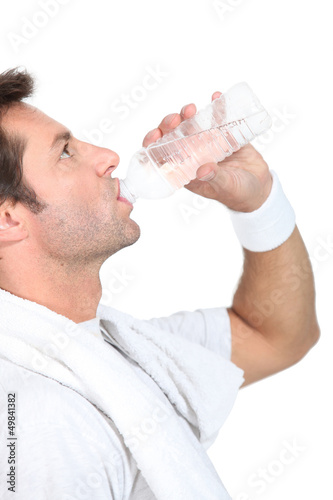 Photo: Man in gym clothes drinking a bottle of water Man in gym clothes drinking a bottle of water