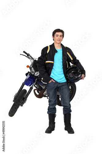 Photo: Teenager boy standing by a motorcycle Teenager boy standing by a motorcycle