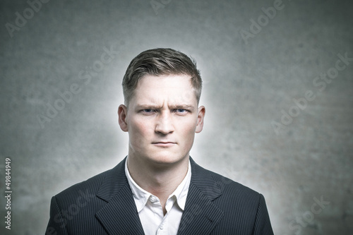 Photo: Junger Geschäftsmann ist nicht sehr fröhlich. Junger Geschäftsmann ist nicht sehr fröhlich.