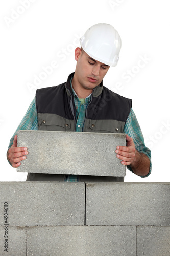 Photo: Bored tradesman laying cinder blocks Bored tradesman laying cinder blocks