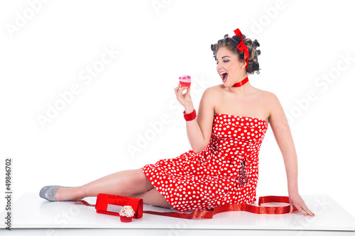 Photo: Hübsche junge Frau im Pin Up Style mit Cupcake Hübsche junge Frau im Pin Up Style mit Cupcake