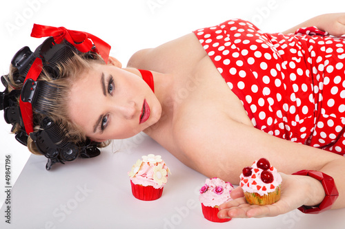 Photo: Hübsche junge Frau im Pin Up Style mit Cupcake Hübsche junge Frau im Pin Up Style mit Cupcake