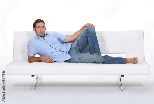 Photo: Sulky man lying on a couch Sulky man lying on a couch
