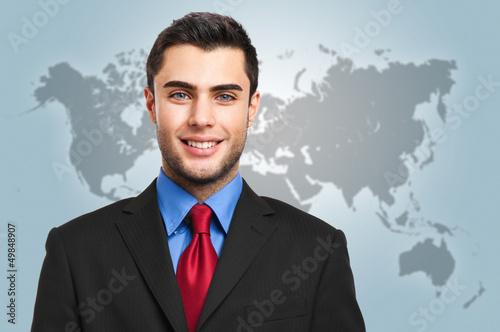 Photo: Smiling businessman with the world on the background Smiling businessman with the world on the background