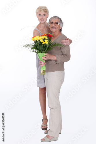 Photo: Woman giving her mother flowers Woman giving her mother flowers