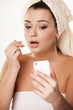 girl  fixes her makeup and uses her smartphone as a mirror