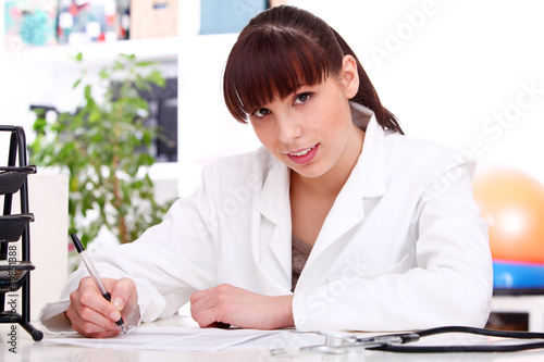 Photo: Young beautiful doctor at table Young beautiful doctor at table
