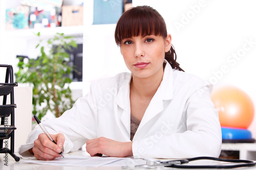 Photo: Young beautiful doctor at table Young beautiful doctor at table