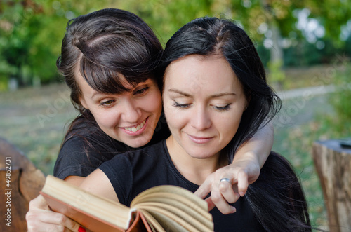 Photo: Friends sharing a book Friends sharing a book
