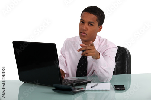 Photo: Office worker at his desk threatening with finger Office worker at his desk threatening with finger