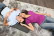 Woman cuddling man laid on a carpet