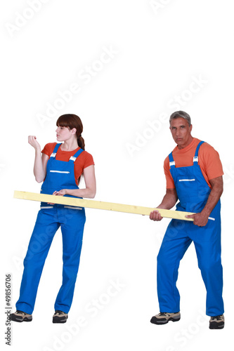 Photo: Man and woman holding wood Man and woman holding wood