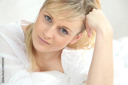 Photo: Young woman laid on a bed Young woman laid on a bed