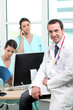 Doctor sitting with nurses at a computer