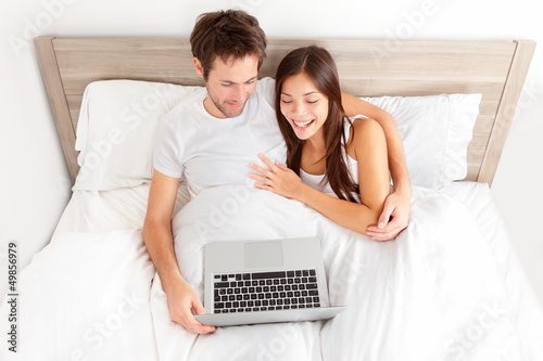 Photo: Young couple relaxing in bed Young couple relaxing in bed