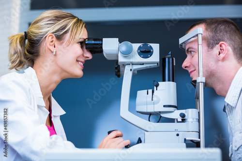 Photo: Optometry concept - handsome young man having his eyes examined Optometry concept - handsome young man having his eyes examined