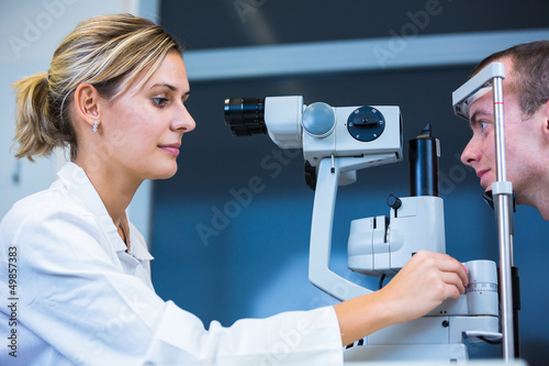 Photo: Optometry concept - handsome young man having his eyes examined Optometry concept - handsome young man having his eyes examined