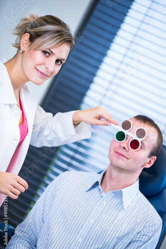 Photo: Optometry concept - handsome young man having his eyes examined Optometry concept - handsome young man having his eyes examined