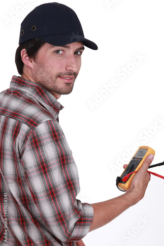 Photo: Tradesman holding a multimeter Tradesman holding a multimeter