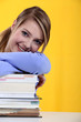 Student leaning on  books