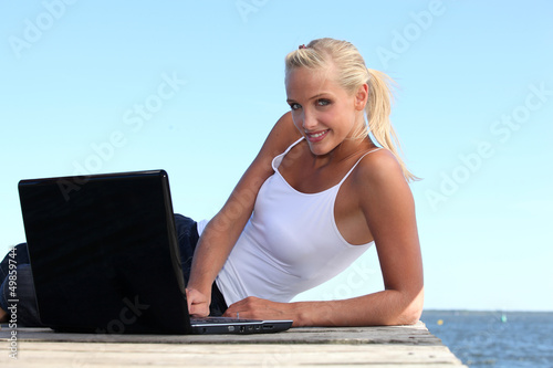 Photo: Woman with computer in a dock Woman with computer in a dock