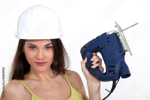 Photo: Woman with an electric jigsaw Woman with an electric jigsaw