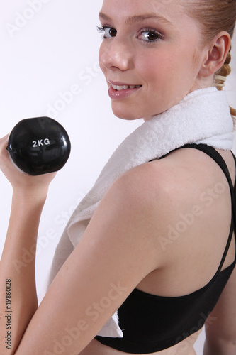 Photo: female doing her workout with a dumbbell female doing her workout with a dumbbell
