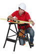 A carpenter taking measures.