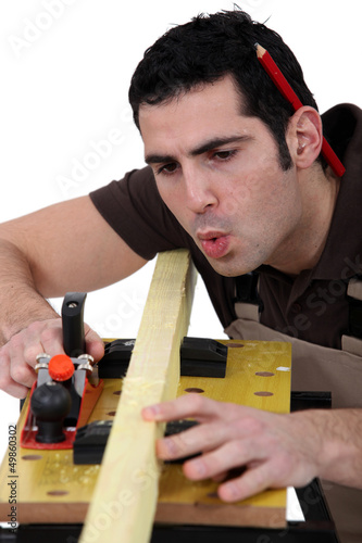 Photo: Carpenter planning timber Carpenter planning timber