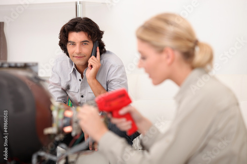 Photo: technician working while the client is talking on the phone technician working while the client is talking on the phone