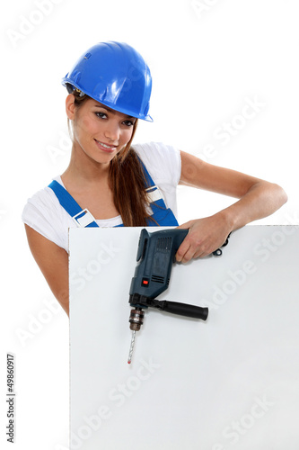 Photo: Attractive model with drill and poster Attractive model with drill and poster