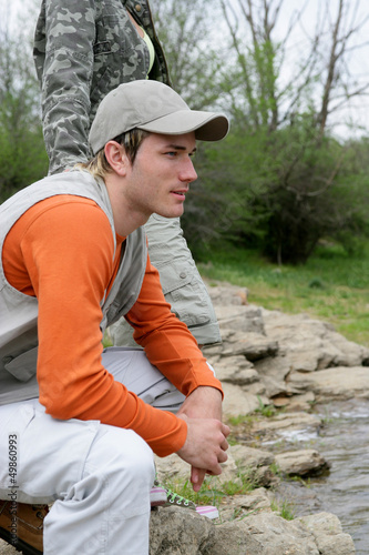 Photo: Man sitting at a riverside Man sitting at a riverside