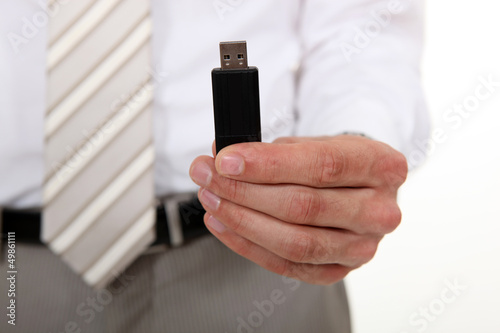 Photo: Businessman holding a USB stick Businessman holding a USB stick