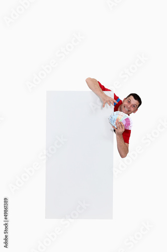 Photo: Man behind white panel with cash Man behind white panel with cash