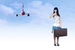 Young woman on the vintage baggage wait on the flying