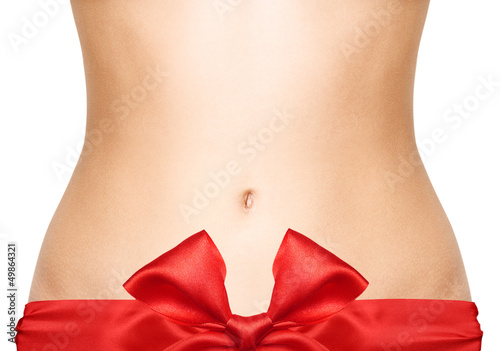 Photo: Woman belly with red bow isolated on white background Woman belly with red bow isolated on white background