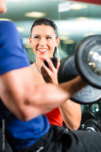 Photo: Trainer und Mann mit Hanteln im Fitnessstudio Trainer und Mann mit Hanteln im Fitnessstudio
