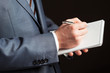Businessman making notes on the paper, black background
