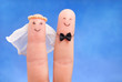 just married concept -  newlyweds painted at fingers against blu