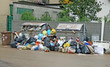 bags of rubbish and waste bins in the middle of the road full of