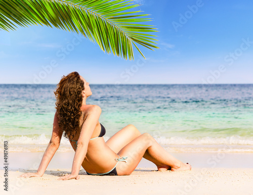 Photo: woman is sitting on beach woman is sitting on beach