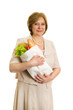 An elderly woman holds a package with vegetables in the hands