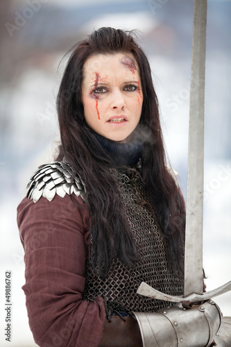 Photo: Woman in the medieval costume holding a sword Woman in the medieval costume holding a sword